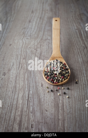 Bunch of mixed pepper grains on a wooden spoon Stock Photo