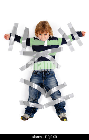 Young angry boy glued to the wall with duct tape Stock Photo