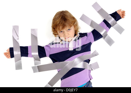 Young angry boy glued to the wall with duct tape Stock Photo