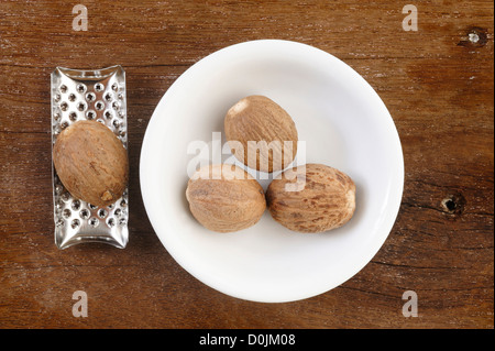 nutmeg and grater on wooden table background Stock Photo