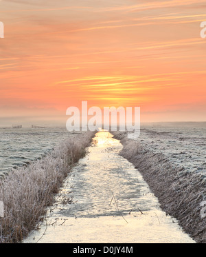 A view along a drainage channel at dawn. Stock Photo