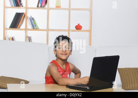 Boy working on a laptop and smiling Stock Photo