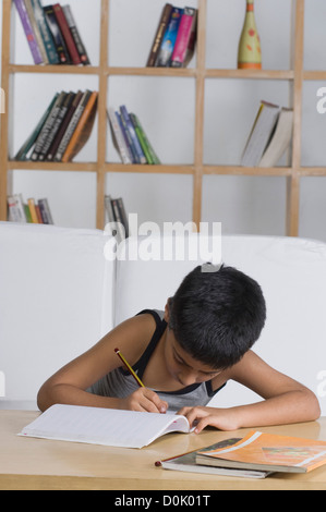 Boy doing homework at desk Stock Photo