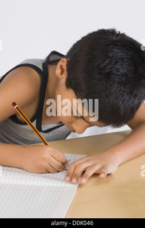 Boy doing homework at desk Stock Photo