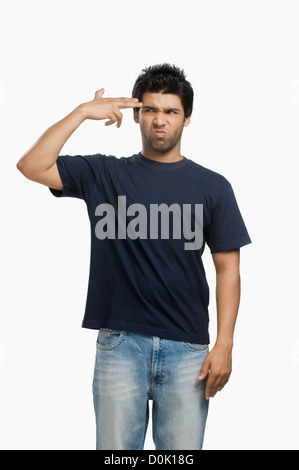 Man making gun sign with fingers at his head Stock Photo