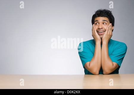 Man looking sideways with his head in his hands Stock Photo