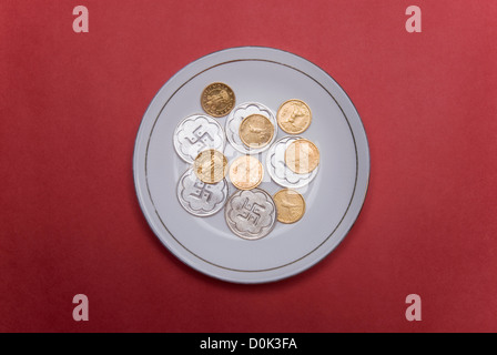 Close-up of gold and silver coins in a plate Stock Photo
