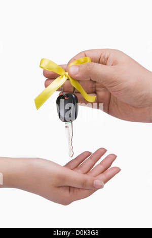 Close-up of a person's hand giving a car key to another person Stock Photo