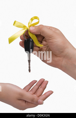 Close-up of a person's hand giving a car key to another person Stock Photo