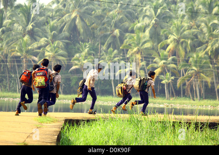 School children running to school in rural kerala Stock Photo