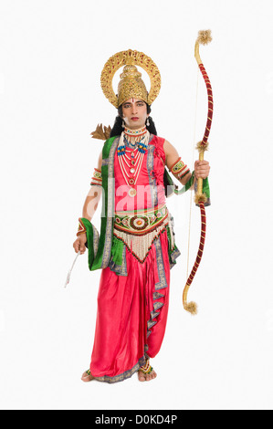 Portrait of a stage artist dressed-up as Rama the Hindu mythological character and holding a bow and arrow Stock Photo