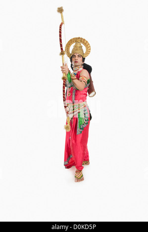 Man dressed-up as Rama and holding a bow and arrow Stock Photo