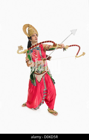 Man dressed-up as Rama and holding a bow and arrow Stock Photo