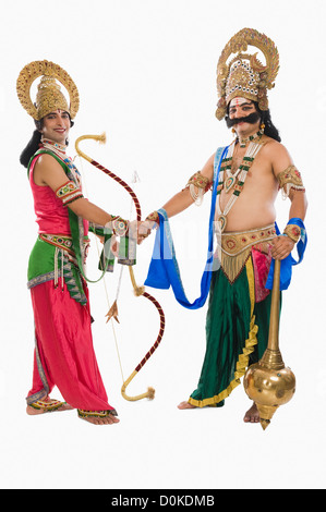 Two stage artists dressed-up as Rama and Ravana and shaking hands Stock Photo