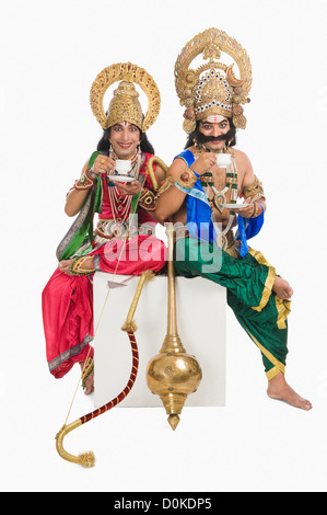 Two stage artists dressed-up as Rama and Ravana and drinking tea Stock Photo
