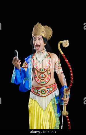 Man dressed-up as Rama reading text message Stock Photo