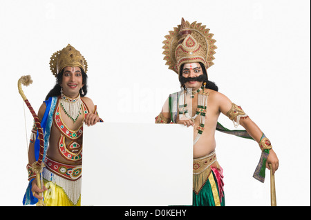 Two men dressed-up as Rama and Ravana and holding a blank placard Stock Photo