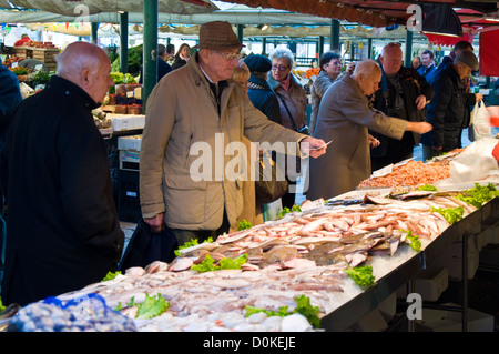 Elderly senior people buying fish from a market stall at the Fish Market in Venice Stock Photo