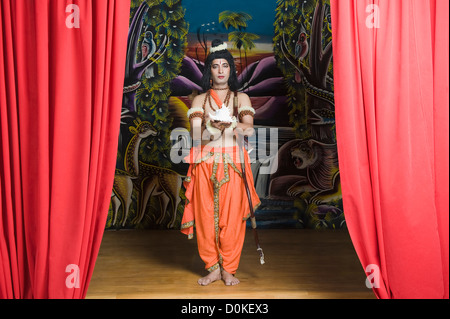 Man dressed-up as Rama holding a conch shell Stock Photo