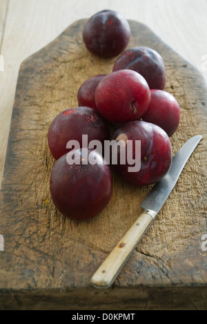 Plums on wooden cutting board Stock Photo