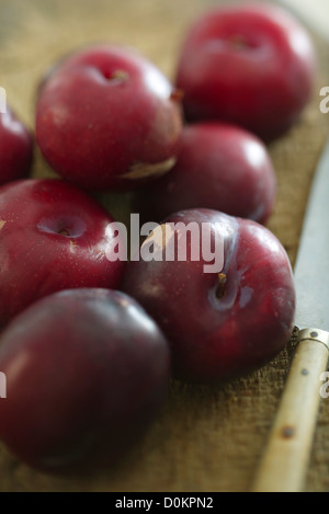 Plums on wooden cutting board Stock Photo