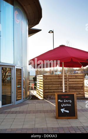 A blackboard outside a Nando's restaurant with a play on words saying Man Eating Chicken. Stock Photo