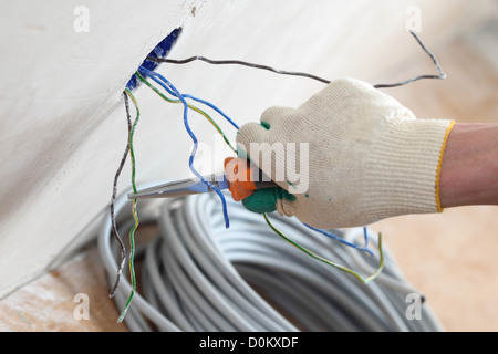 worker puts the wires in the wall Stock Photo