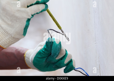 worker puts the wires in the wall Stock Photo