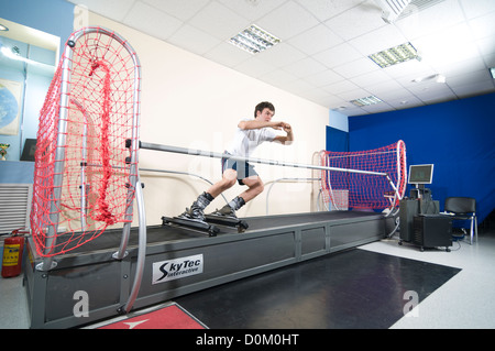 Athlete working out on interactive ski simulator at the gym Stock Photo