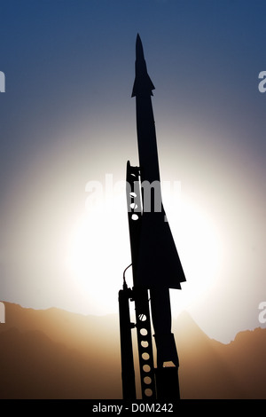 A Nike Ajax missile sits on launcher silhouetted against Sun in missile park outside museum White Sands Missile Range in New Stock Photo