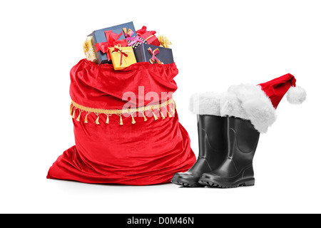 Santa accessories, pair of boots and bag full of presents isolated against white background Stock Photo