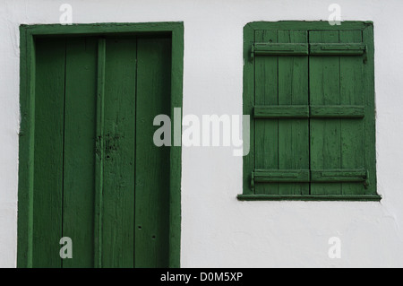 Wooden door and window shutter. Old house white wall background texture. Stock Photo