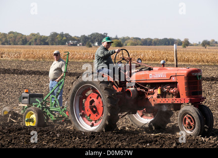 Farmall Model H plowing a field on a farm near Hebron, Illinois during an antique tractor plowing demonstration. Stock Photo