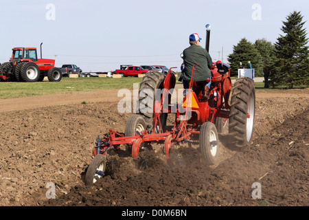 1950 Farmall, Model M, plowing a field with a 3-bottom plow on a farm near Hebron, Illinois. Stock Photo