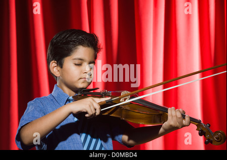 Schoolboy playing a violin on a stage Stock Photo