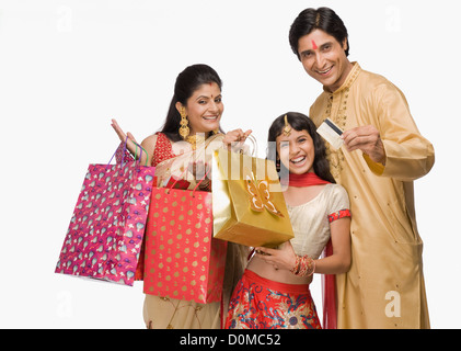 Couple and their daughter carrying shopping bags and credit card Stock Photo