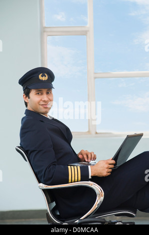 Pilot Using Computer Pilot using a laptop at an airport Stock Photo - Alamy