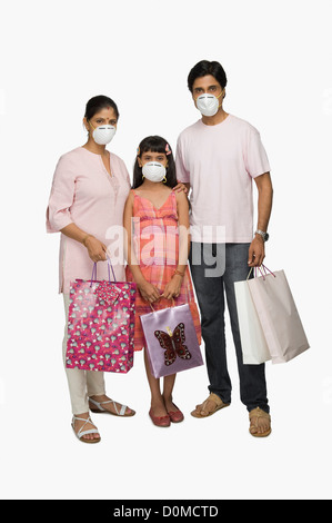 Portrait of a couple wearing flu mask and holding shopping bags Stock Photo