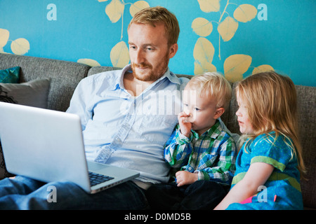 Father with daughter and son using laptop Stock Photo