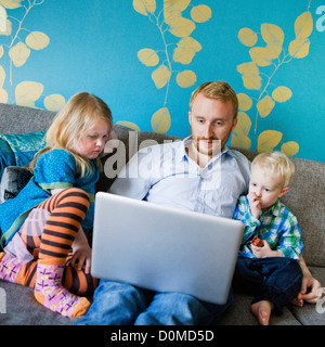 Father with daughter and son using laptop Stock Photo