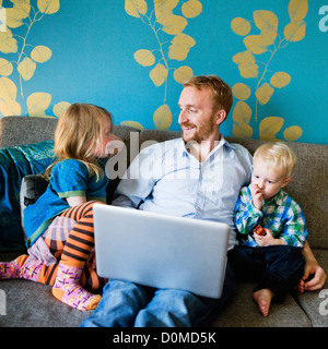 Father with daughter and son using laptop Stock Photo