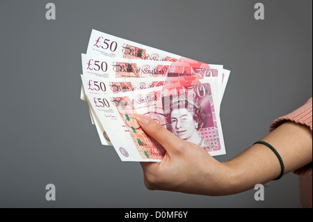 Woman's hand holding fifty pound notes UK British currency Stock Photo