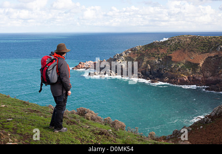 Female walker standing on cliff top on north coast of Jersey, Channel Islands, UK Stock Photo
