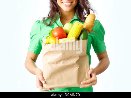 Image of paper packet full of different fruits and vegetables held by female Stock Photo