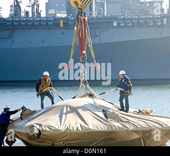 Contractors hoist the X-47B Unmanned Combat Air System (UCAS) demonstrator to the flight deck of the aircraft carrier USS Harry Stock Photo