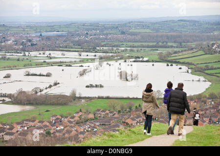 Glastonbury, United Kingdom-November 27th. Tourists on path on Glastonbury Tor.Flood water in the fields surrounding the Glastonbury Tor on the Somerset Levels. Photograph taken from elevated Glastonbury Tor, Glastonbury, Somerset, England. Stock Photo