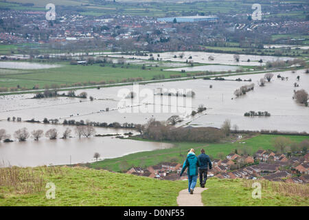 Glastonbury, United Kingdom-November 27th. Tourists on path on Glastonbury Tor.Flood water in the fields surrounding the Glastonbury Tor on the Somerset Levels. Photograph taken from elevated Glastonbury Tor, Glastonbury, Somerset, England. Stock Photo