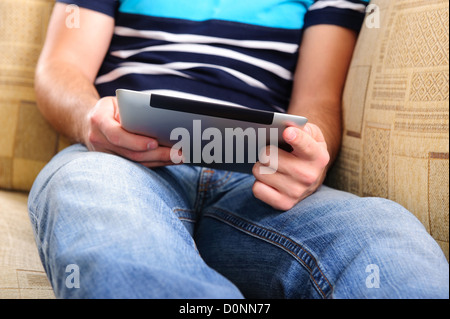 Young man using digital tablet on sofa at home Stock Photo
