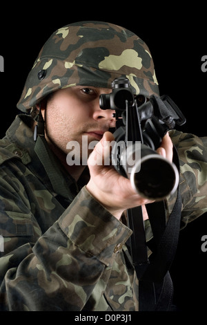 Alerted soldier pointing m16 in studio Stock Photo