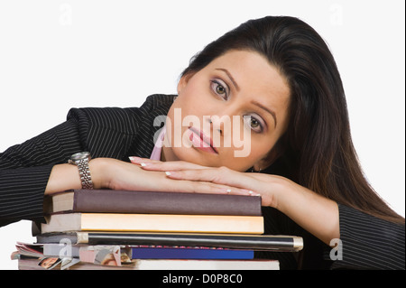 Portrait of a businesswoman resting her face on books Stock Photo